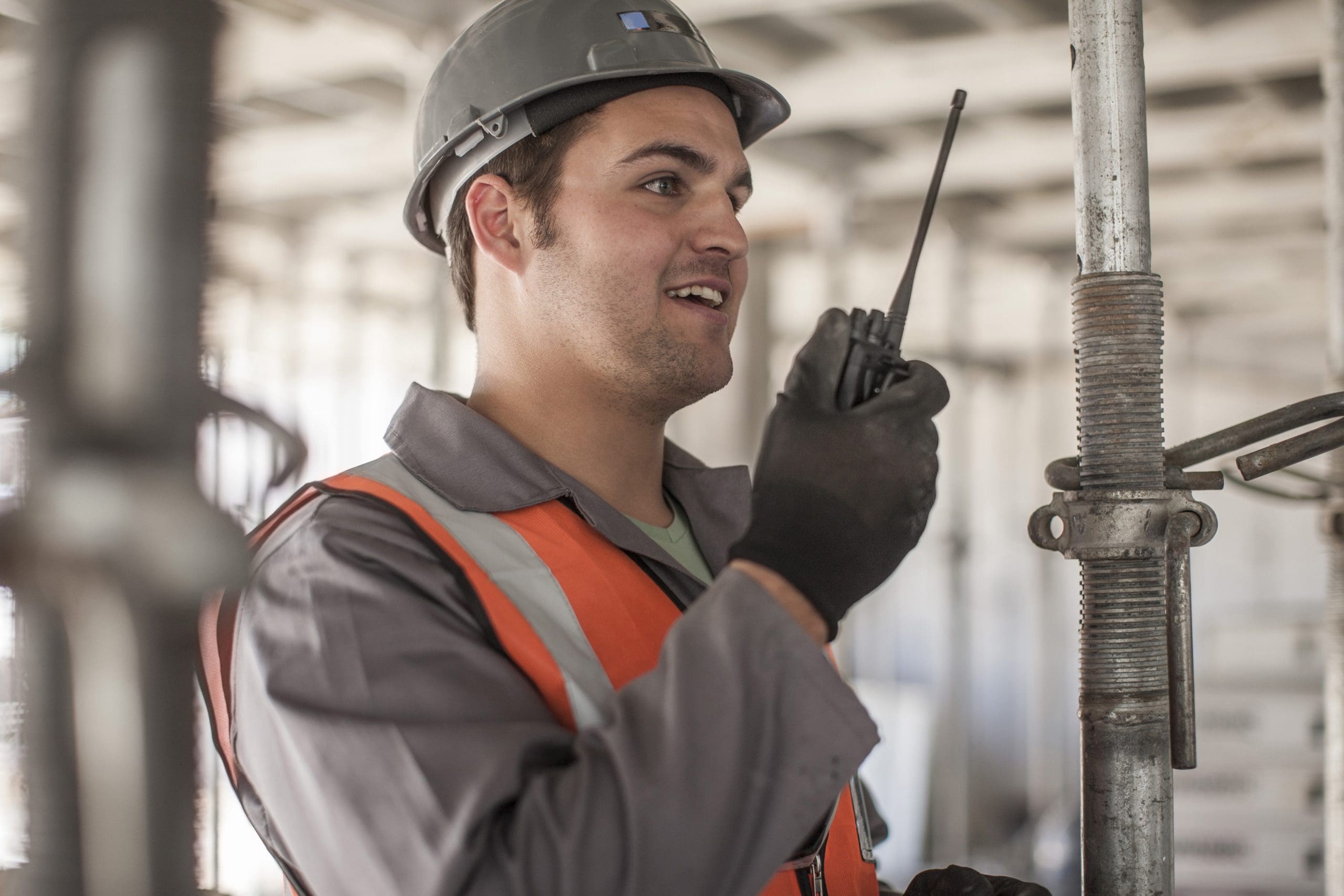 Builder using walkie talkie on construction site PNC380s